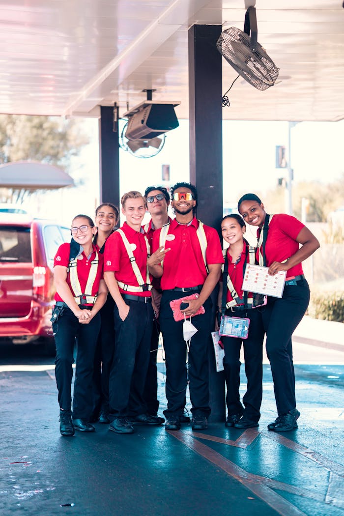 about-01 A diverse group of fast food employees smiling in uniforms outdoors